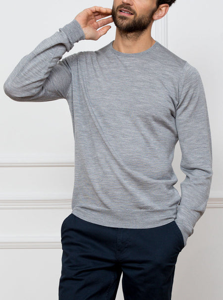 Man wearing silver grey long sleeved crewneck sweater knit in 100% luxury and premium merino wool.